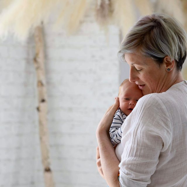 Angharad, nutrition and wellness coach, holding a newborn baby